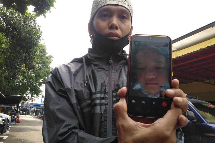Rohendi tengah memperlihatkan hasil tangkapan layar video call terakhir saat anaknya yang nangis ingin pulang, di Mapolrestabes Bandung, Jumat (1/10/2021).