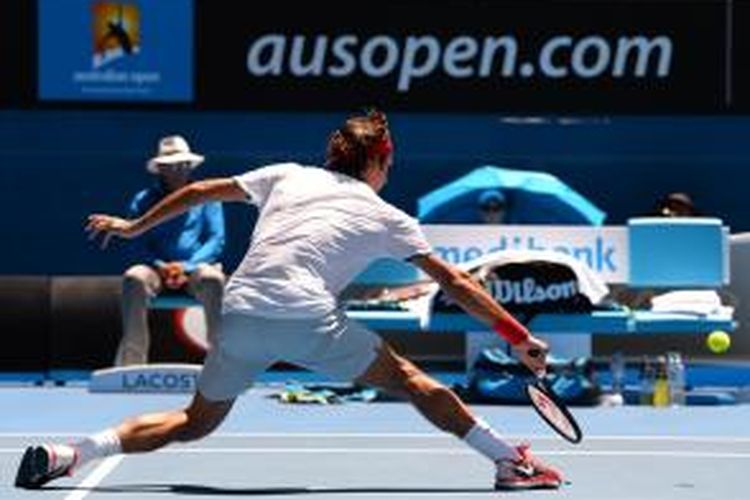 Petenis Swiss, Roger Federer berusaha mengembalikan bola ke arah petenis Australia, James Duckworth pada babak pertama Australian Open di Melbourne Park, Selasa (14/01/2014).