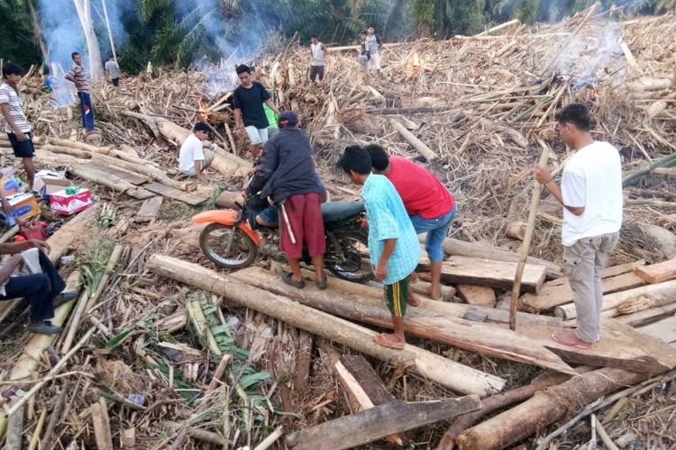 Warga membersihkan jalan karena tertutup puing-puing sisa banjir di salah satu lokasi di Kabupaten Bengkulu Tengah