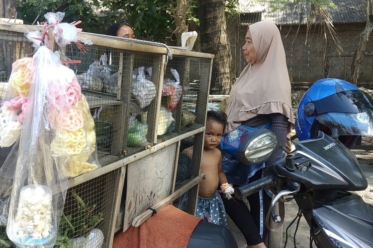 Seorang ibu penjual sayur keliling di Dusun Ebunut yang sedang menjajakan dagangannya