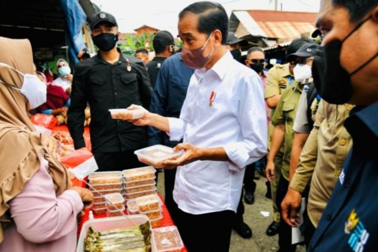 Presiden Joko Widodo berbincang dengan pedagang saat menyerahkan bantuan tunai di Pasar Baru Tanjung Enim, Kabupaten Muara Enim, Provinsi Sumatra Selatan (Sumsel), Senin (24/1/2022).