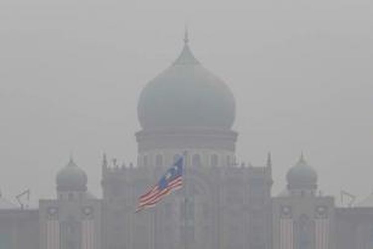 Bendera kebangsaan Malaysia di Kantor Perdana Menteri di Putrajaya, tampak diselimuti kabut asap tebal, 11 September 2015. Kabut asap berasal dari kebakarna hutan dan lahan di Sumatera dan Kalimantan, Indonesia.