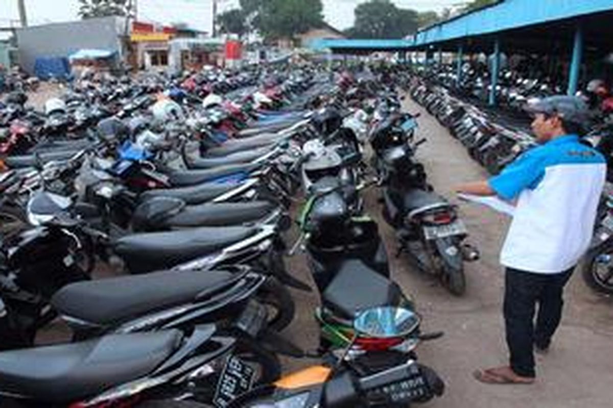 Petugas menjaga kendaraan roda dua yang diparkir di tempat parkir di Stasiun Sudimara, Tangerang Selatan, Selasa (7/5/2013). Fasilitas park n ride  tersebut mampu menampung lebih dari 500 sepeda motor dan 40 mobil milik penumpang kereta api.
