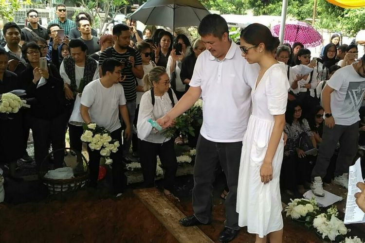 Artis peran dan penyanyi Mikha Tambayong dan ayahnya Michael Tambayong menaburkan air mawar di pusara Deva Malaihollo di TPU Menteng Pulo, Tebet, Jakarta Selatan, Selasa (5/3/2019).