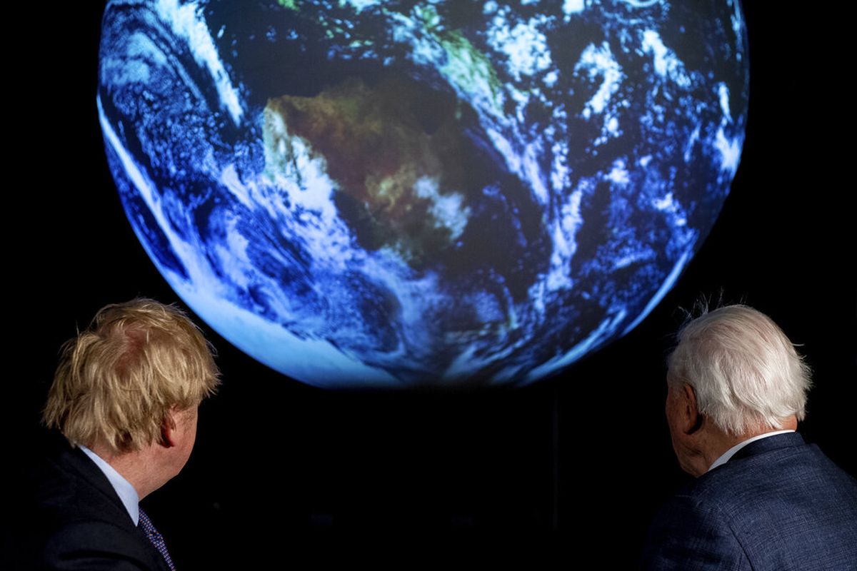 Perdana Menteri Inggris Boris Johnson, kiri, dan David Attenborough melihat proyeksi planet bumi selama peluncuran KTT Iklim PBB COP26 mendatang yang diselenggarakan Inggris di London, Selasa 4 Februari 2020.
