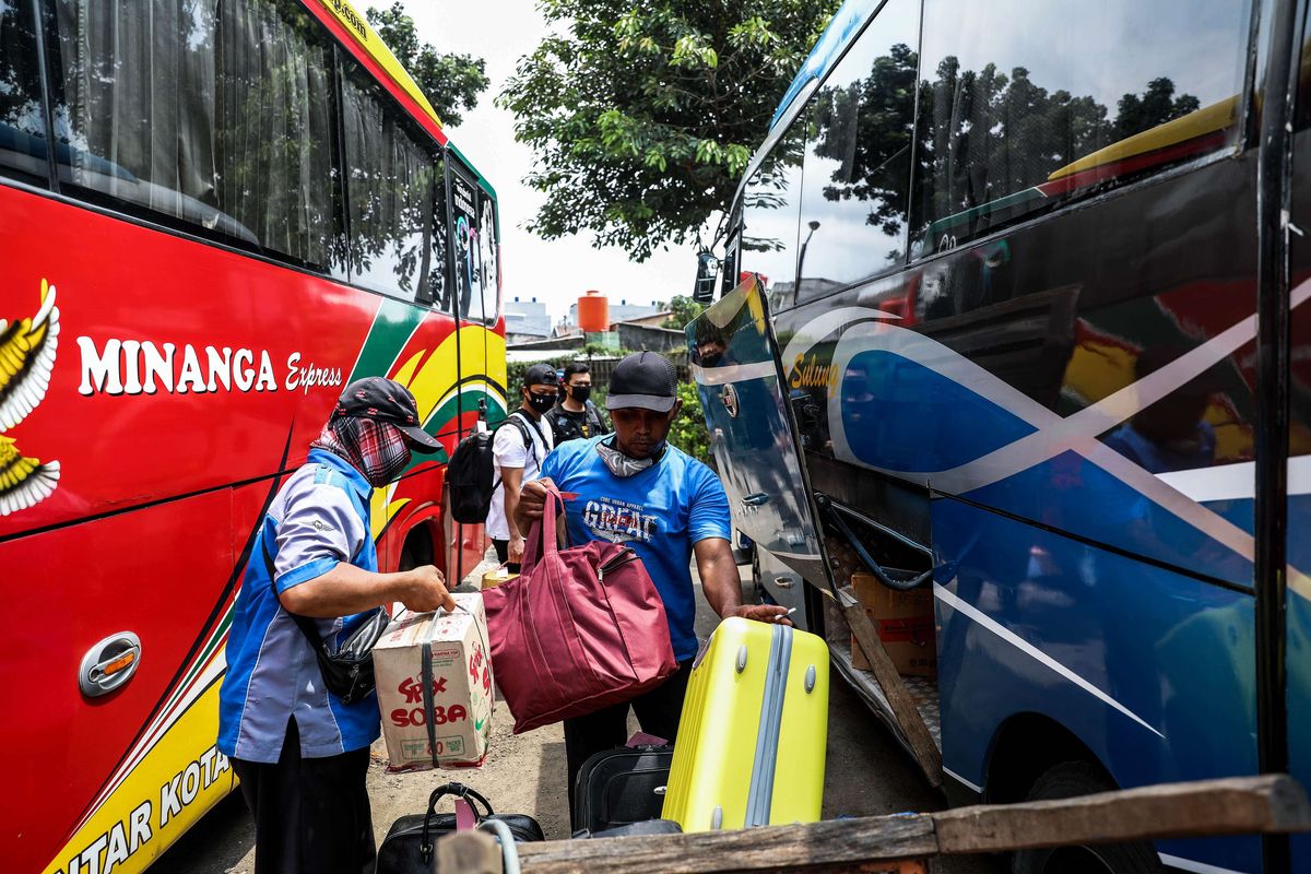 Pekerja memindahkan barang penumpang ke bus di Terminal Kalideres, Jakarta Barat, Jumat (24/4/2020). Presiden RI Joko Widodo memutuskan untuk melarang mudik lebaran 2020 di tengah pandemi COVID-19 mulai 24 April guna mencegah perluasan penyebaran COVID-19 di wilayah Indonesia.
