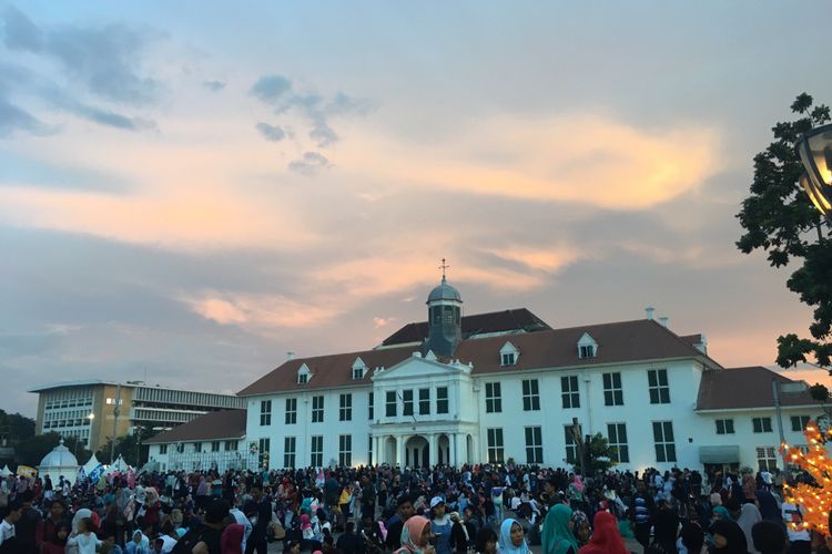 Wisata kota tua dipadati pengunjung, tepatnya duduk lesehan di pelataran Museum Fatahillah saat malam tahun baru 2018, Jakarta, Minggu (31/12/2017).