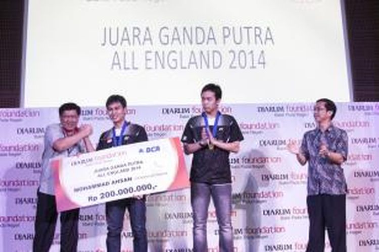 Pebulu tangkis ganda putra Mohammad Ahsan (dua kiri)/Hendra Setiawan menerima penghargaan dari Program Director Bakti Olahraga Djarum Foundation, Yoppy Rosimin di Galeri Indonesia Kaya, Mall Grand Indonesia, Jakarta Pusat, Selasa (18/3/2014). Pasangan ganda putra Indonesia ini menerima penghargaan berupa uang sebesar Rp 200 juta dari Djarum Foundation dan Rp 200 juta dari Yayasan Jaya Raya usai memenangi All England, pekan lalu. 