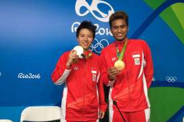 Liliyana Natsir dan Tontowi Ahmad memamerkan medali emas yang diraihnya di Olimpiade Rio 2016, Rabu (17/8/2016).