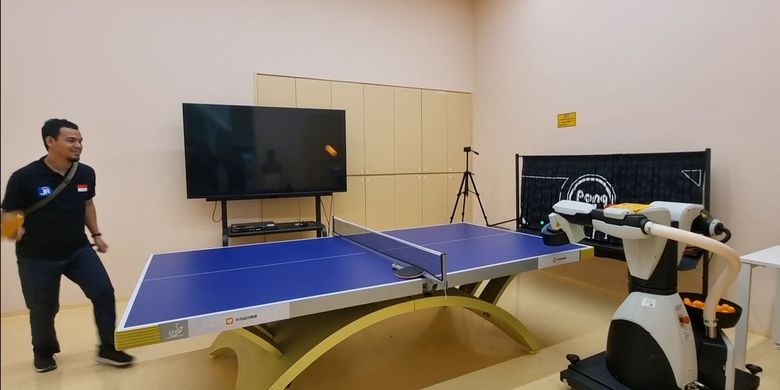 Seseorang yang bertindak sebagai sampel, bermain ping pong dengan robot Huawei di laboratorium Huawei di Danau Songshan, Dongguan, China. 