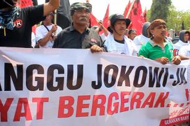 Puluhan warga Kabupaten Kuningan, berunjuk rasa di sekitar pintu masuk tol Ciperna menuju Jakarta, di Kecamatan Talun, Kabupaten Cirebon, Senin siang (13/10/2104). Mereka membentangkan spanduk, dan berteriak 