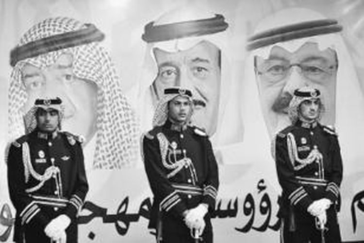 Pasukan Pengawal Kerajaan berjaga di depan foto Raja Abdullah bin Abdulaziz (kanan), Putra Mahkota Salman bin Abdulaziz (tengah), dan Deputi II Perdana Menteri Mugren bin Abdulaziz di dalam festival kebudayaan Janadriya di Der’iya, Riyadh, Arab Saudi, Selasa (18/2).