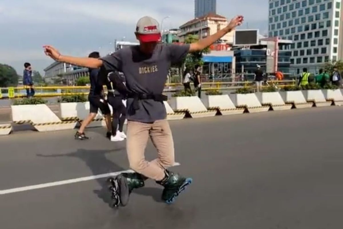 Seorang pehobi sepatu roda bernama Aldo (19) yang sedang melakukan trik saat menggunakan sepatu roda di CFD Sudirman-Thamrin, Jakarta Pusat, Minggu (19/2/2023).