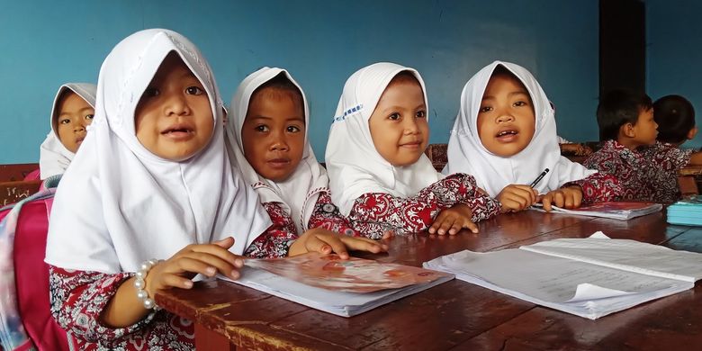 Murid sekolah dasar di Kabupaten Cianjur, Jawa Barat, ini terpaksa duduk berdempetan hingga empat orang karena ruang kelas mereka ada yang rusak terdampak bencana.