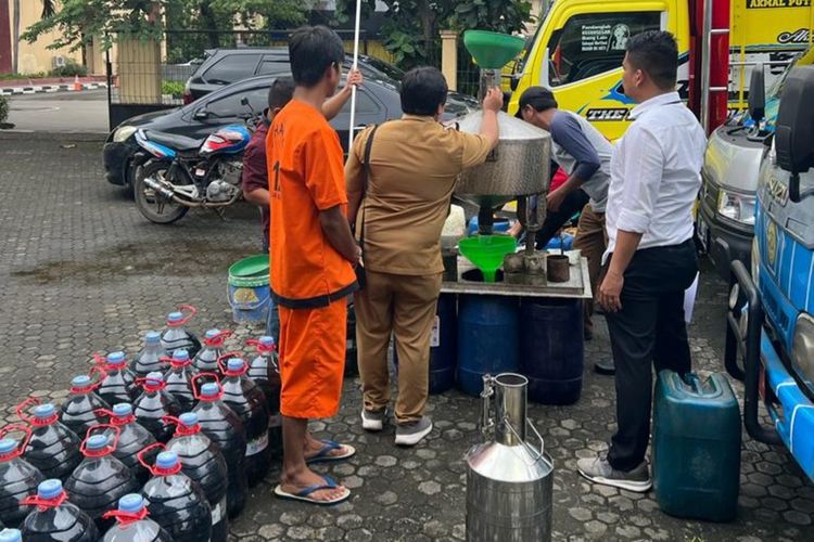 Petugas saat menghitung ulang barang bukti BBM jenis Pertalite disaksikan tersangka saat di Polda Banten