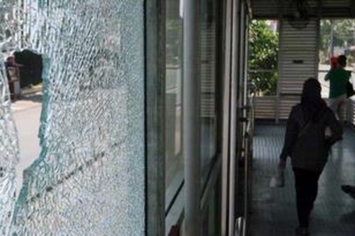 satu dari tiga jendela kaca yang pecah akibat terkena tembakan di Halte Bus TransJakarta Cawang Otista, tak jauh dari Polsek Jatinegara, Jakarta, Minggu (5/8/2012). Pada dini hari enam buah halte bus TransJakarta ditembak. Diduga penembak mengunakan senapan angin. 
