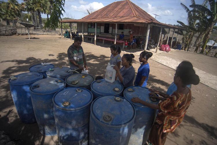 Foto dirilis Rabu (6/2/2019), menunjukkan Octovianus Alexander Rajariwu (kiri) melayani pembelian bahan bakar minyak (BBM) kepada warga di Desa Raekore, Sabu Raijua, Nusa Tenggara Timur. Stasiun Pengisian Bahan Bakar Umum (SPBU) kompak dan Agen Premium dan Minyak Solar (APMS) dibangun di Pulau Sabu, mengubah asa masyarakat dengan program BBM Satu Harga yang dijalankan Pertamina, termasuk memberikan angin segar bagi para petani bawang di desa tersebut.