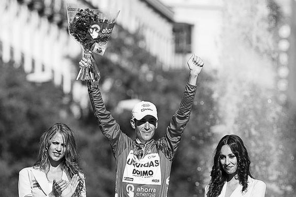 Pebalap sepeda Italia, Vincenzo Nibali (tengah), mengangkat tangan di podium setelah keluar sebagai juara umum Vuelta a Espana yang berakhir di Madrid, Spanyol, Minggu (19/9).