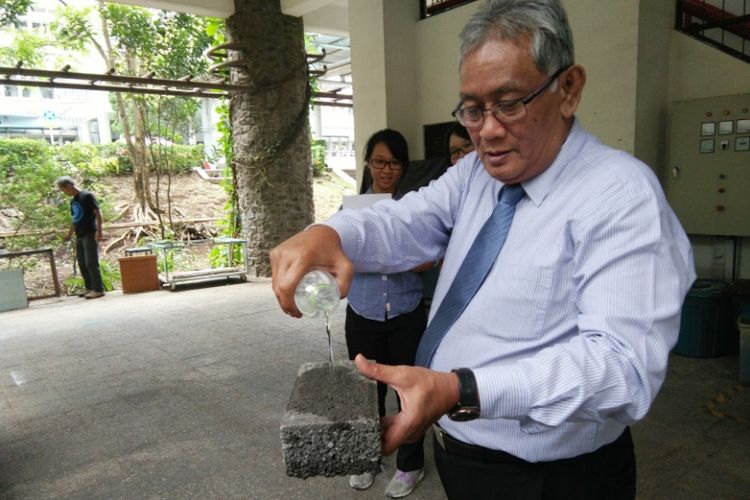 Dosen ITB Prof Dr Ir Bambang Sunendar Purwasasmita saat mempraktikan cara kerja bahan geopori yang mampu menyerap air. Teknologi itu diciptakan Bambang untuk menawarkan solusi mengatasi banjir di perkotaan. 