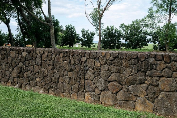 Ilustrasi pagar batu yang mengelilingi kompleks rumah Zuck di Hawaii.