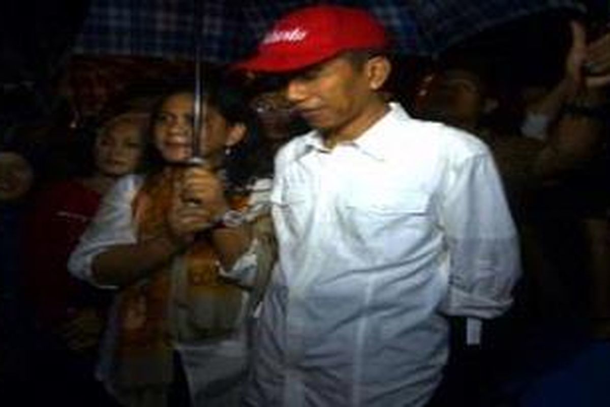 Gubernur DKI Jakarta Joko Widodo bersama isterinya Iriana Widodo mengecek lokasi banjir di Pejaten Timur, Pasar Minggu, Jakarta Selatan, Selasa (15/1/2013) malam. Disana Jokowi langsung menyerahkan bantuan berupa uang, beras, dan lauk pauk kepada warga yang menjadi korban pengungsian.