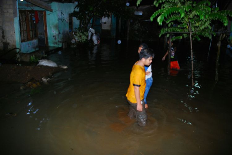 Sejumlah warga sedang melintas di lokasi banjir yang merendam 100 rumah di Kampung Bantarjati Kaum, RT 5 RW 10, Kelurahan Bantarjati, Kecamatan Bogor Utara, Kota Bogor, Minggu (9/7/2017)