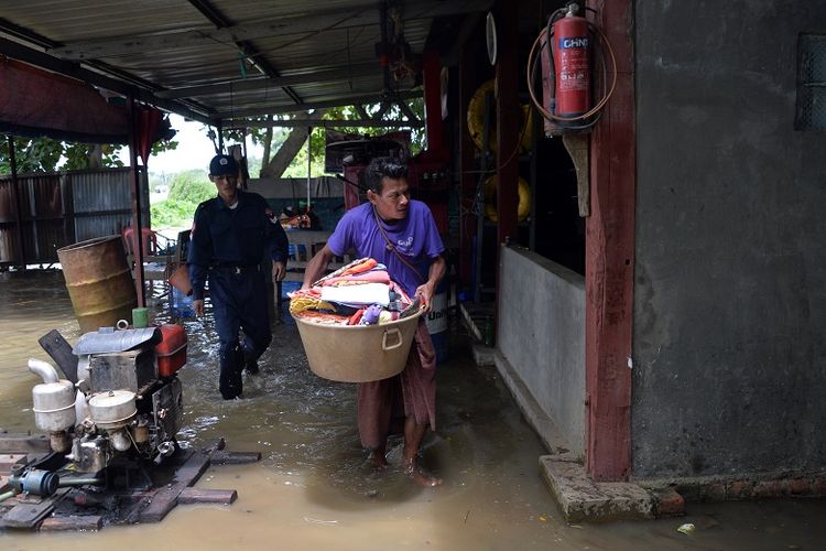 Warga menyelamatkan harta benda mereka setelah banjir melanda ketika bendungan Swar Chaung di Bago, Myanmar tak mampu menahan luapan air usai hujan deras yang melanda kawasan itu.
