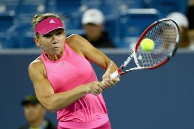 Petenis Rumania, Simona Halep, mengembalikan bola ke arah petenis Belgia, Kirsten Flipkens, pada babak kedua Western & Southern Open di Cincinnati, Selasa (12/8/2014).