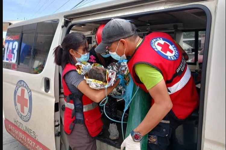Gadis kecil berusia tiga tahun yang berhasil diselamatkan usai terjebak hampir 60 jam karena bencana tanah longsor di Filipina, dan kemudian dibawa ke dalam mobil ambulans.