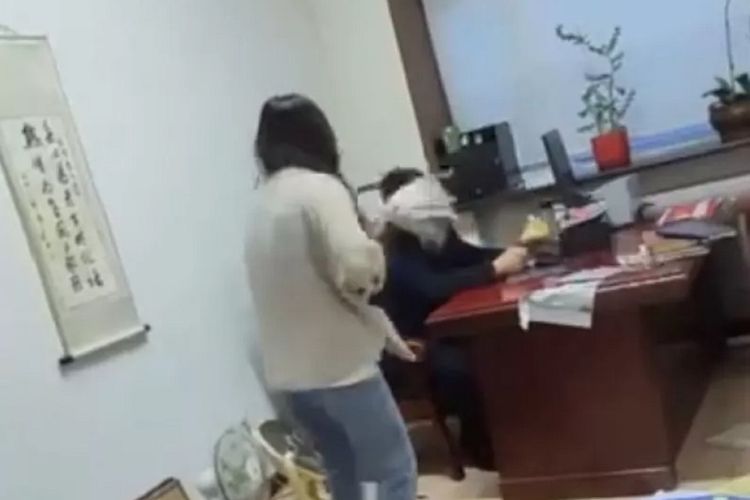 Tangkapan layar video yang viral di Weibo memperlihatkan Wang Chunhui, seorang atasan di kantor pemerintahan China dipukul kain pel oleh anak buahnya, Zhou, karena mengirim pesan cabul.