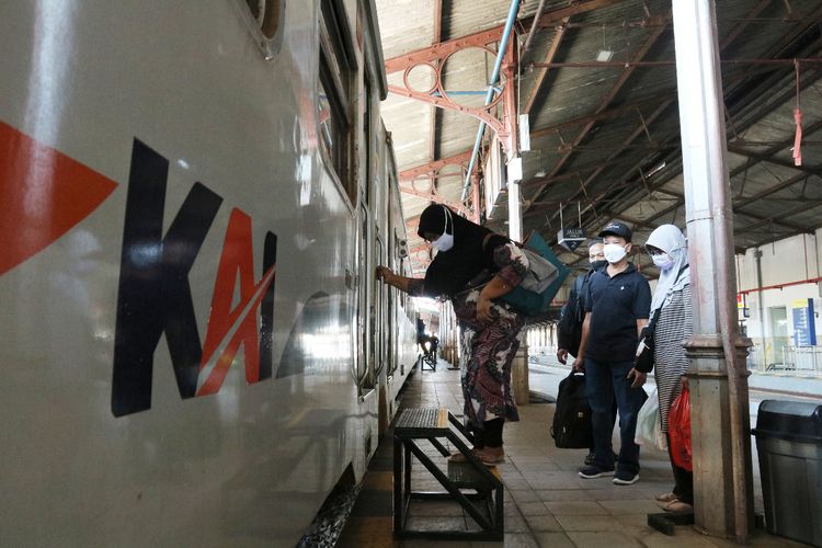NAIK KERETA—Salah satu calon penumpang naik kereta api di Stasiun Madiun, Selasa (12/10/2021).