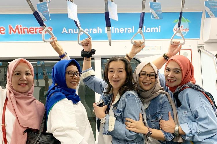 Ibu-ibu muda tengah menggunakan MRT Jakarta untuk mobilitas belanja
