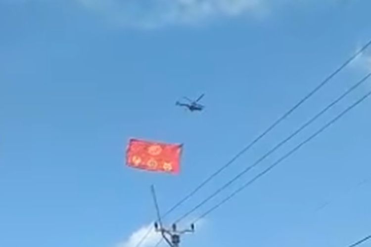 Tangkapan layar video bernarasi helikopter dibiarkan berkeliling untuk mengibarkan bendera China.