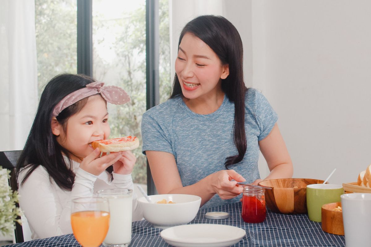 Ilustrasi anak makan bersama orangtua.