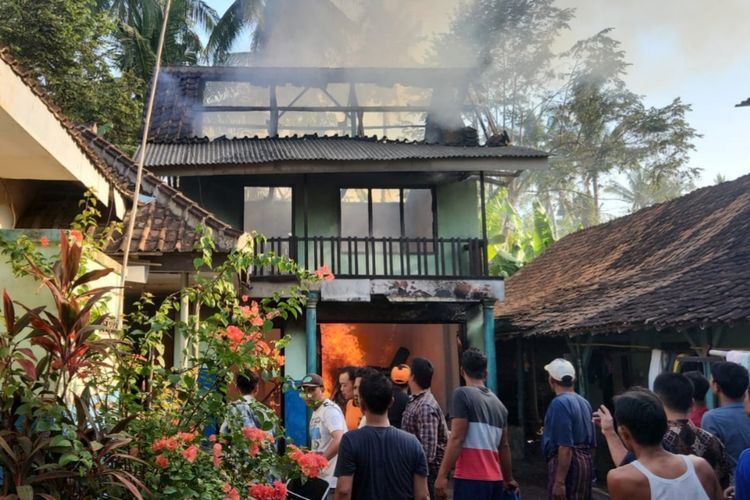 Warga berjibaku memadamkan api yang melalap sebuah rumah dan satu unit mobil di Desa Rejoagung, Kecamatan Srono, Banyuwangi, Jawa Timur, Senin (11/12/2023) pagi. Kebakaran ini diduga akibat korsleting listrik.