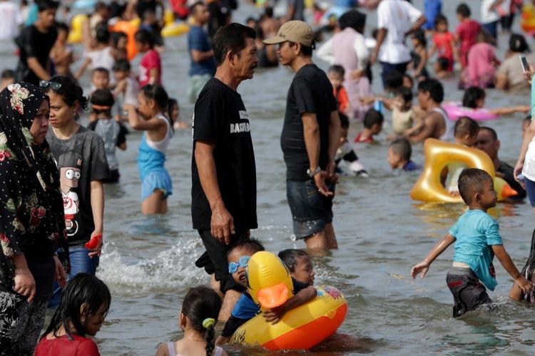 Pengunjung memanfaatkan liburan mengunjungi pantai di kawasan Taman Impian Jaya Ancol, Jakarta, Selasa (27/6/2017). Sejumlah lokasi wisata di Jakarta padat pengunjung pada libur lebaran. 