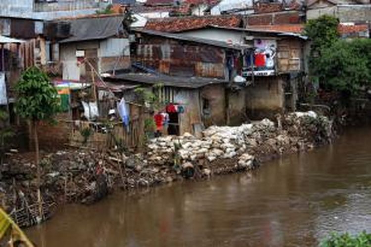 Deretan rumah warga berdiri di bantaran Kali Ciliwung di Kawasan Bidara Cini, Jakarta Timur, Selasa (4/3/2014). Prmprov DKI Jakarta akan membuat sodetan Ciliwung sepanjang 1,27 kilometer yang akan dilakukan mulai kawasan Bidaracina sampai dengan Kali Cipinang yang dihubungkan dengan KBT. Ratusan kepala keluarga (KK) yang bertempat tinggal di jalur pembuatan sodetan Ciliwung menuju Kanal Banjir Timur (KBT) akan direlokasi ke rumah susun. Warta Kota/angga bhagya nugraha