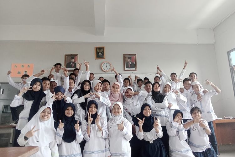Guru Honorer Eva Agustini saat berfoto dengan para muridnya di ruang kelas SMP Negeri 27 Jakarta.