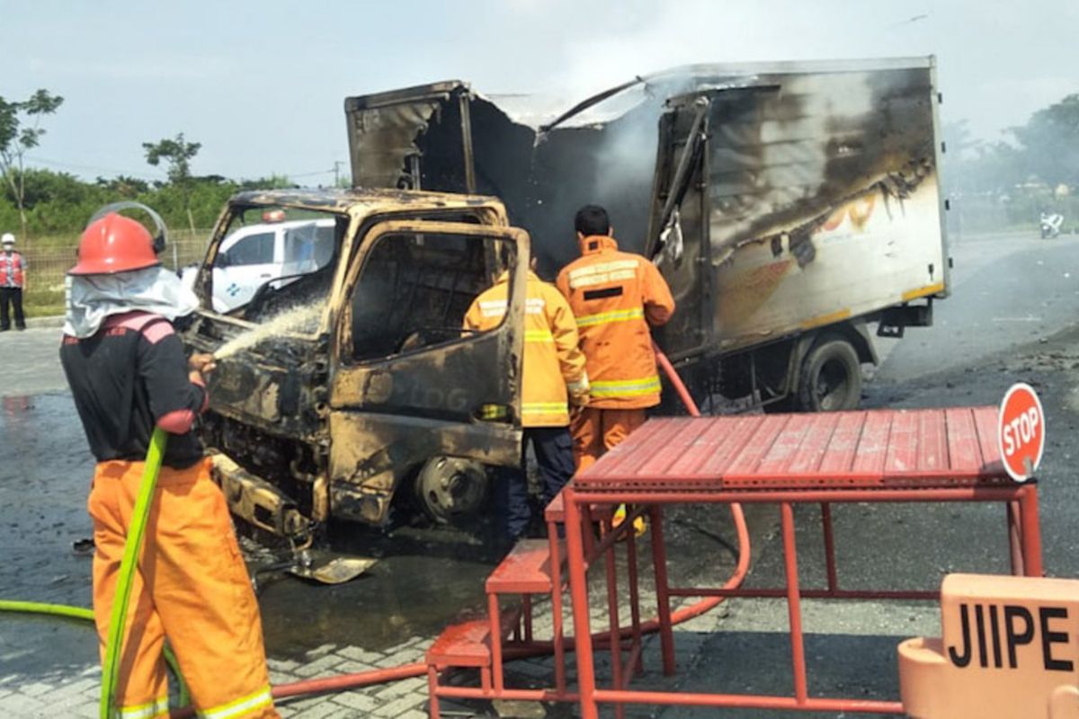 Kondisi truk boks usai dilalap api pasca menabrak sepeda motor di Jalan Raya Desa Banyuwangi, Kecamatan Manyar, Gresik, Jumat (30/4/2021).