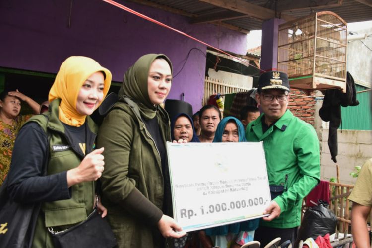 Gubernur Jawa Barat (Jabar) Ridwan Kamil bersama Ketua Umum Jabar Bergerak Atalia Praratya saat menyerahkan bantuan untuk korban bencan banjir di Kabupaten Karawang kepada Bupati Karawang Cellica Nurrachdiana, Sabtu (4/1/20202).