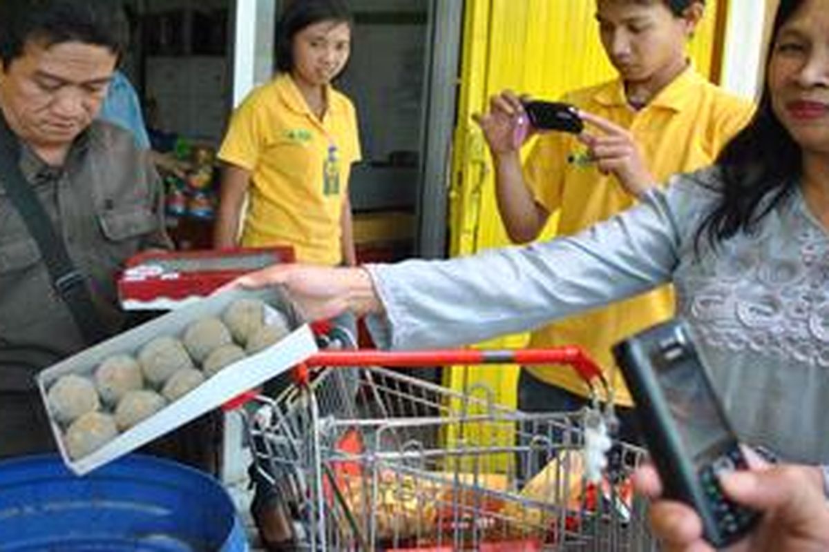Petugas Badan POM sedang memsnahkan makanan dan minuman yang ditemukan sudah kadaluarsa .
