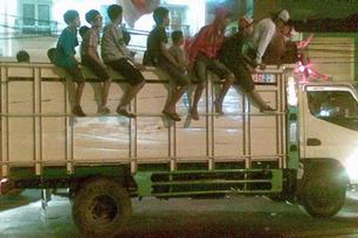 Sekelompok remaja menumpang sebuah truk untuk mengikuti pawai takbiran sedang melintasi Jalan Tambak, Pegangsaan, Jakarta Pusat, Selasa (30/8/2011) malam.