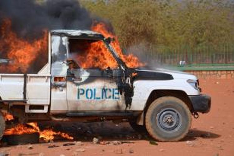 Sebuah mobil polisi terbakar akibat aksi unjuk rasa anti-majalah Charlie Hebdo di ibu kota Niger, Niamey, Sabtu (17/1/2015).