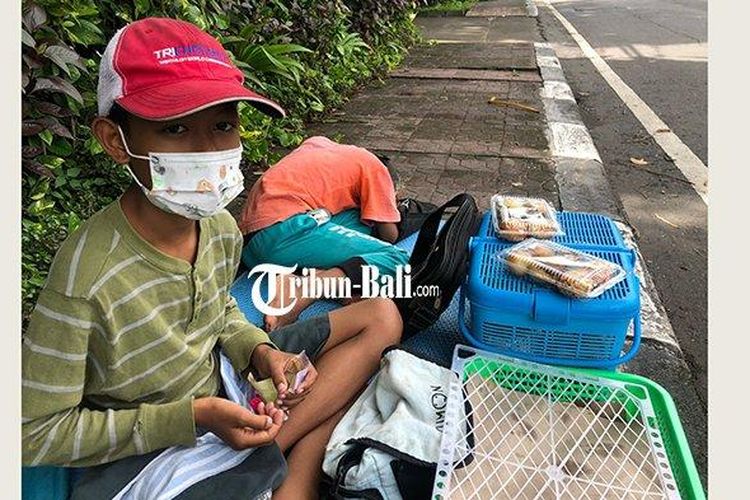 Firman bocah kelas 4 SD yang menjual jajanan di pinggir Jalan Hayam Wuruk Denpasar untuk membeli HP, Kamis 10 Februari 2022. 