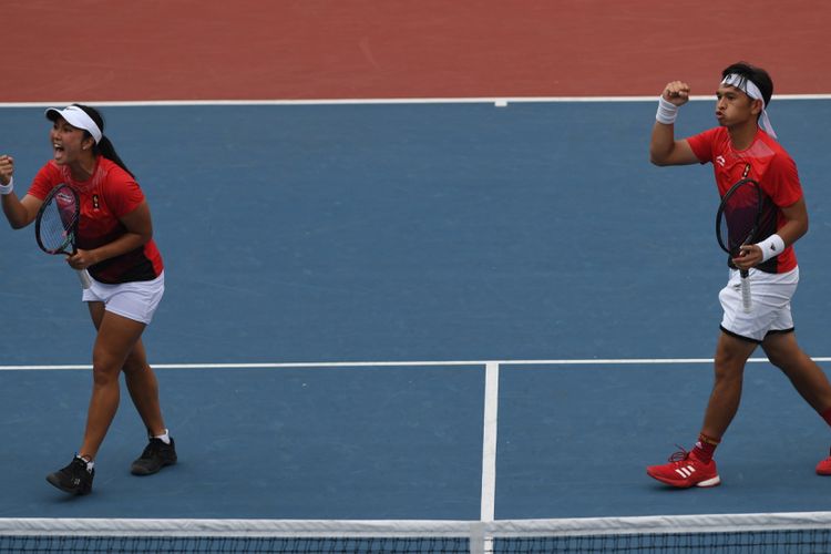 Ekspresi ganda campuran Indonesia Aldila Sutjiadi (kiri) dan Christopher Rungkat seusai meraih poin dari petenis Thailand Luksika Kumkhum dan Sonchat Ratiwatana pada final tenis ganda campuran Asian Games 2018 di Jakabaring Sport City, Palembang, Sumatera Selatan, Sabtu (25/8/2018).