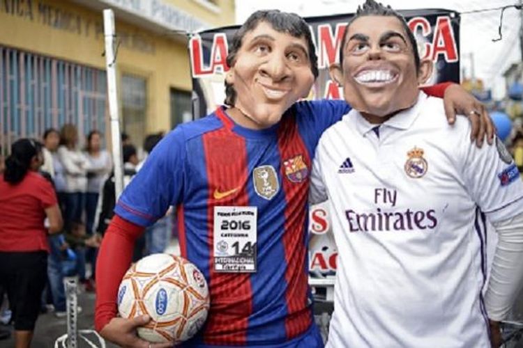 Dua orang yang memakai topeng serta kostum Lionel Messi dan Cristiano Ronaldo memeriahkan karnaval All Saints Day di Guatemala pada awal November 2016. 