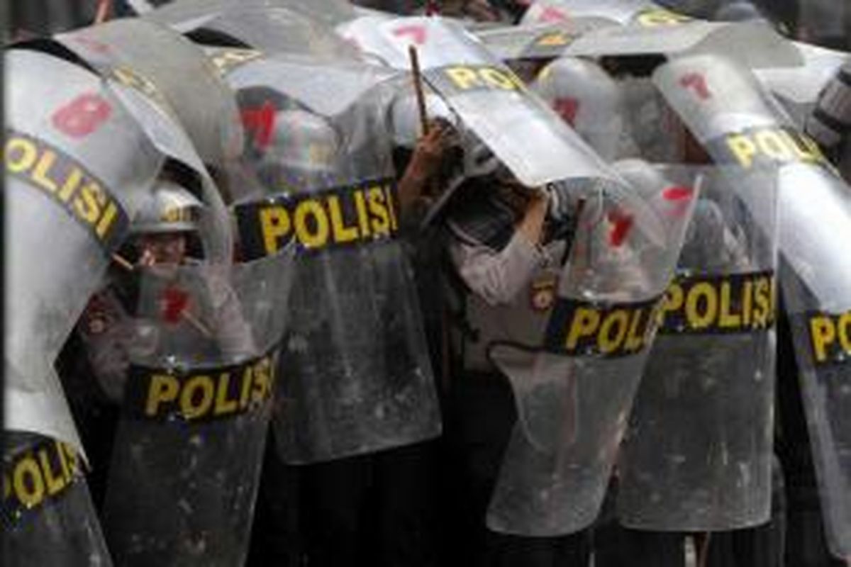 Polisi terlibat bentrokan dengan warga Kampung Pulo, Jakarta Timur, di Jalan Jatinegara Barat, Kamis (20/8/2015). Bentrokan terjadi karena warga menolak digusur dan dipindahkan untuk normalisasi Kali Ciliwung.