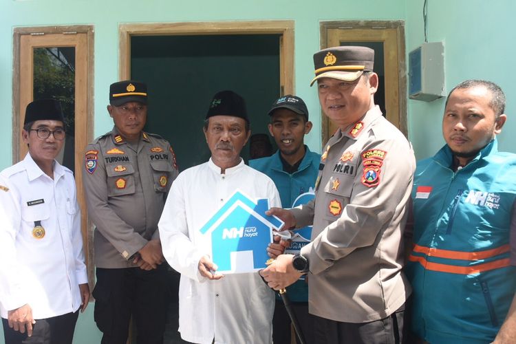 Kapolres Lamongan AKBP Yakhob Silvana Delareskha (dua dari kanan), secara simbolis menyerahkan bantuan bedah rumah kepada Choirun Nasiran saat peresmian di Desa Bojoasri, Kecamatan Kalitengah, Lamongan, Jawa Timur, Rabu (11/1/2023).