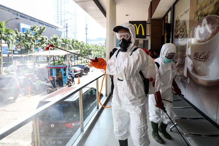 Petugas menyemprotkan cairan di bagian luar gerai Sarinah department store, Jakarta Pusat, Selasa (17/3/2020). Kegiatan ini untuk meminimalisir penyebaran penyakit akibat virus Covid-19.