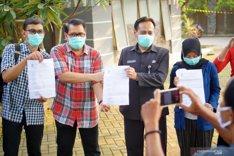 Direktur RSUD dr Iskak Tulungagung dr Supriyanto Dharmoredjo, Sp.B, M.Kes. (kedua kanan) dan tiga dari total empat tenaga medis yang dinyatakan sembuh COVID-19 menunjukkan surat keterangan sehat pada hari pertama kebebasan mereka keluar dari rumah karantina di Asrama RSUD dr  Iskak KabupatenTulungagung, Jawa Timur, Rabu (22/4/2020). ANTARA/Destyan Sujarwoko